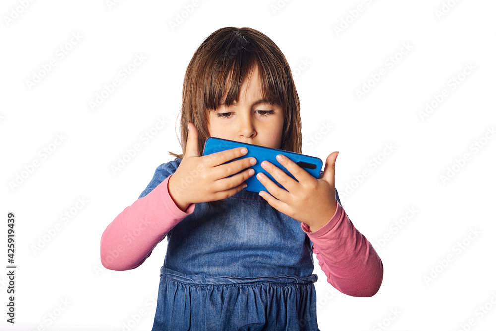 bad habits of young 4 year old girl. looking at the phone with concentration. concept of problem with social media, addiction child problems bad habits of young 4 year old girl. looking at the phone with concentration. concept of problem with social media, addiction child problems
