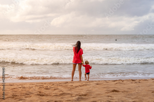 MOTHER AND SON ON THE BEACH SAND.