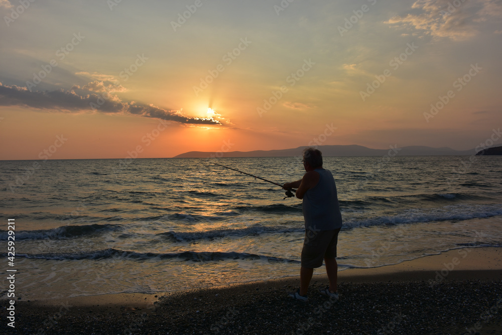 A fisherman fishing at sunset