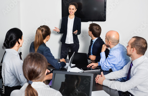 Diligent friendly manager making speech during business meeting in office