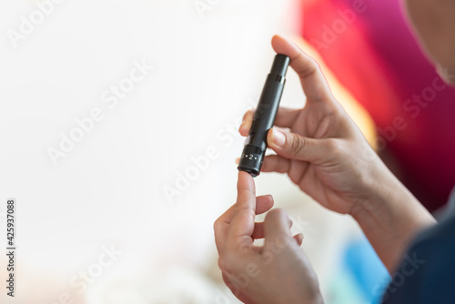 Wallpaper Mural Close up of woman hands using lancet on finger to check blood sugar level by Glucose meter. Use as Medicine, diabetes, glycemia, health care and people concept. Torontodigital.ca