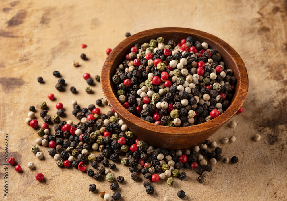 Pepper mix. Black, red, white, and green peppercorns on an old cutting board. Pepper mix. Black, red, white, and green peppercorns on an old cutting board.
