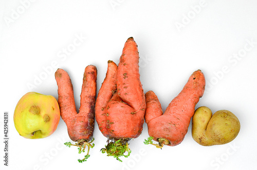 Ugly vegetables: carrots, spinner and apple on white background.