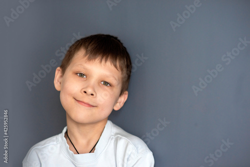 portrait of a boy 8-10 on a blue isolated background, space for text, selective focus