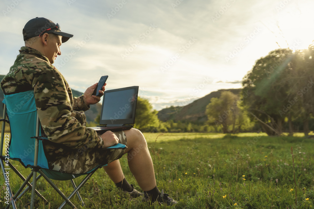 man with laptop and smart phone outdoors