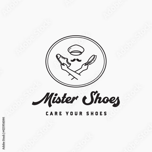 Hand holding shoes and brush for care and clean logo
