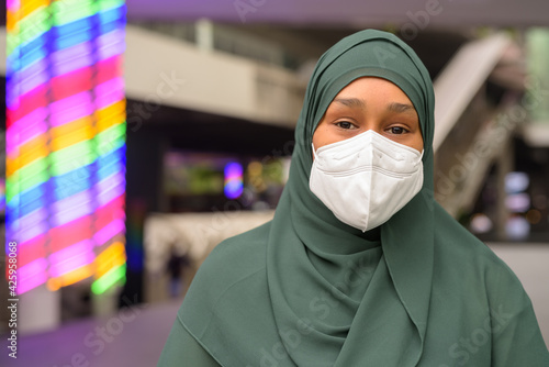 Beautiful black African Muslim woman wearing face mask outdoors