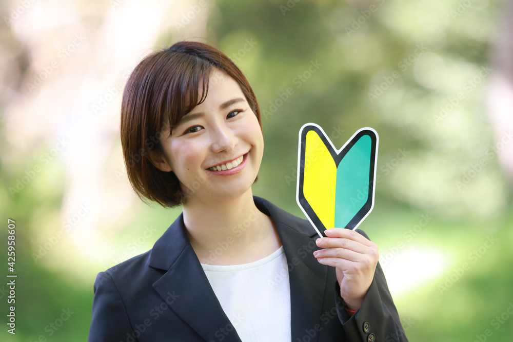 初心者マークを持つ女性社員 初心者マークを持つ女性社員