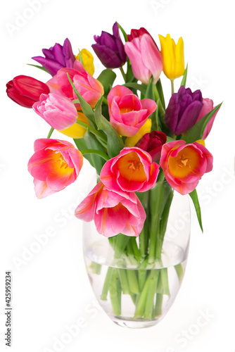 Fototapeta Naklejka Na Ścianę i Meble -  Many beautiful colorful tulips with leaves in a glass vase isolated on transparent background. Photo with fresh spring flowers for any festive design
