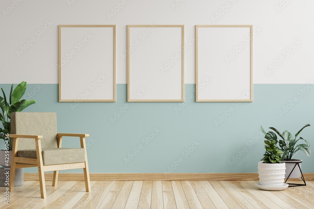 Picture frame on the white and green walls in the living room is decorated with armchairs and plant pots on the floor.3d rendering. Picture frame on the white and green walls in the living room is decorated with armchairs and plant pots on the floor.3d rendering.