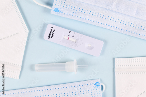 Corona virus rapid antigen test with negative result and medical face masks on blue background