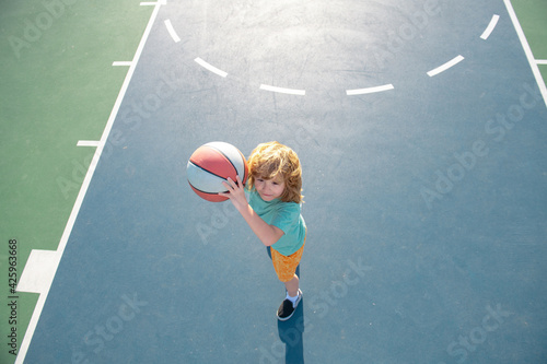 Kid playing basketball with ball. Basketball child player. © Volodymyr