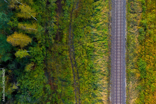 railway track line through autumn forest, view from above