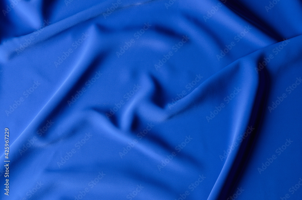 The background is made of a delicate blue chiffon fabric with folds in the form of waves. The background is made of a delicate blue chiffon fabric with folds in the form of waves.