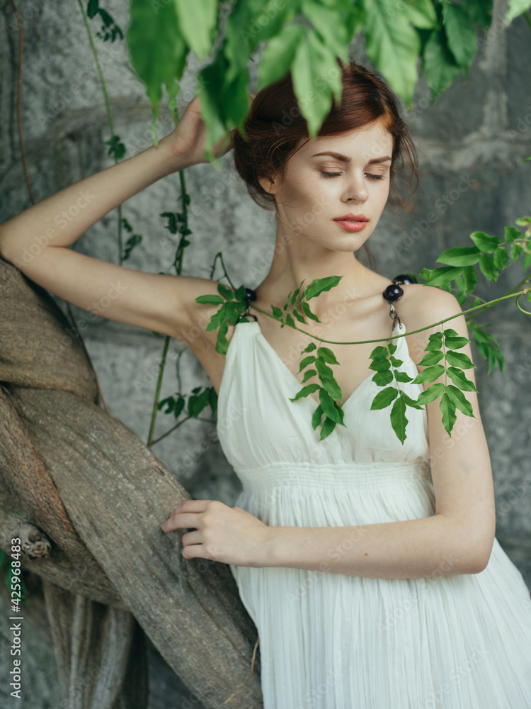 Fototapeta premium Woman in white dress and green leaves luxury nature model