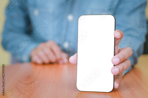 The man is handing out a white mobile phone screen to the front. Text can be placed in copy spaces. Concept of technology, Social and communication