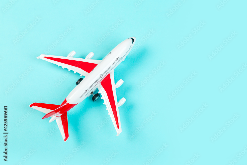 Airplane model, airliner with red wings, on a blue background. travel and transport concept Airplane model, airliner with red wings, on a blue background. travel and transport concept