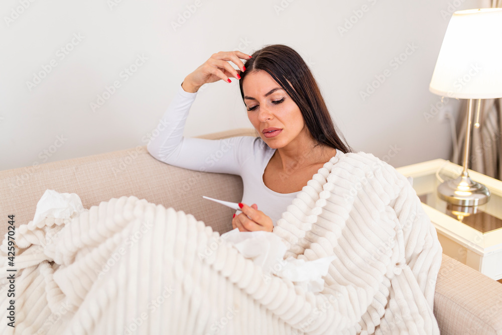 Sick woman with headache sitting under the blanket. Sick woman with seasonal infections, flu, allergy lying in bed. Sick woman covered with a blanket lying in bed with high fever and a flu, resting. Sick woman with headache sitting under the blanket. Sick woman with seasonal infections, flu, allergy lying in bed. Sick woman covered with a blanket lying in bed with high fever and a flu, resting.