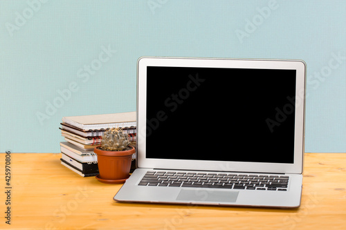 Notebook with notebooks and green succulent on a wooden table. mockup for text