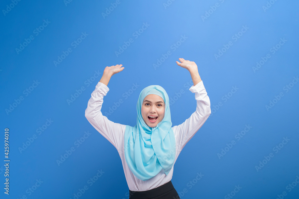 Portrait of a young muslim woman with hijab over blue background studio. Portrait of a young muslim woman with hijab over blue background studio.