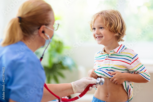 Doctor examining sick child in face mask