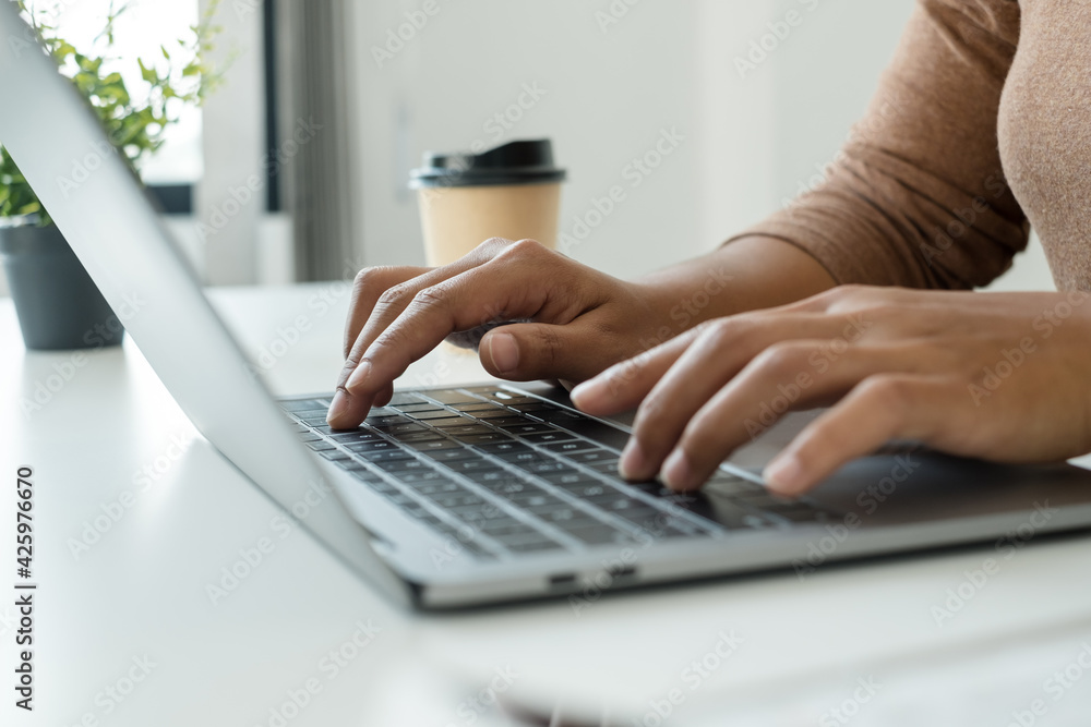 © Orathai - work from home, The hand of a woman who works in finance sits at his desk at home and calculates financial graphs showing the results of his investments, planning the steps of his business growth