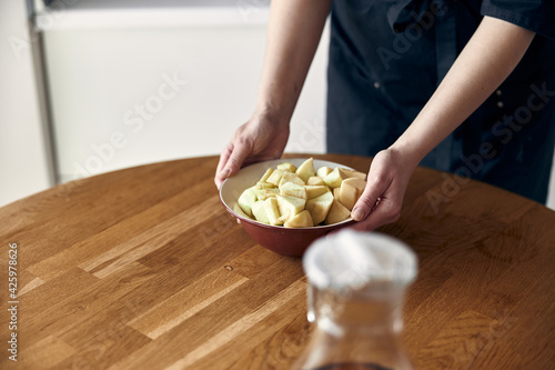 beautiful middle asian woman preparing apples for cooking at cozy stilysh kitchen photo