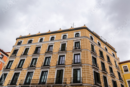 Old Traditional Residential Buildings in Central Madrid. Colorful Facades Against Cloudy Sky © jjfarq