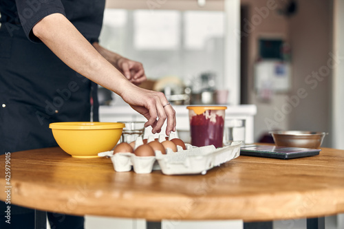 young beautiful mixed race woman is preparing marshmallow at light modern kitchen home