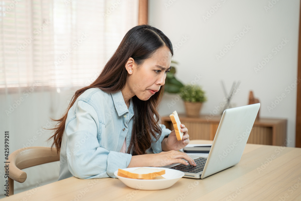 Asian beautiful girl feeling hungry while working on computer at home. Asian beautiful girl feeling hungry while working on computer at home.