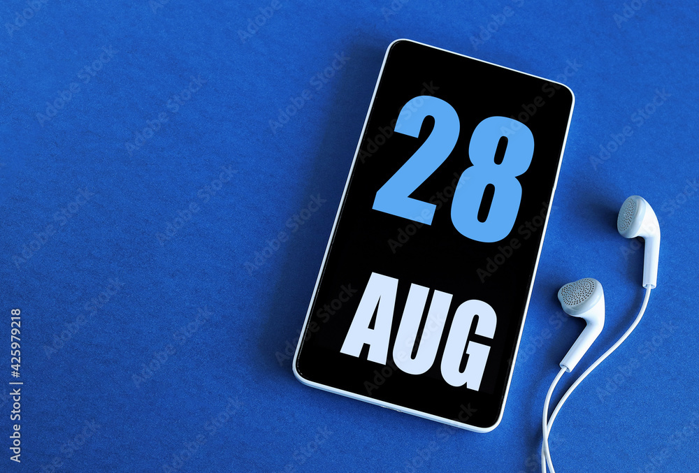 August 28. 28 st day of the month, calendar date. Smartphone and white headphones on a blue background. Place for your text. Summer month, day of the year concept August 28. 28 st day of the month, calendar date. Smartphone and white headphones on a blue background. Place for your text. Summer month, day of the year concept