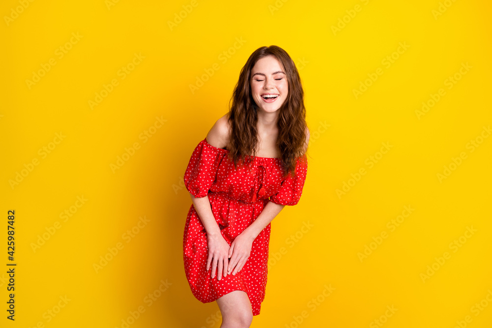 Photo portrait of funky girl laughing in red fancy printed dress isolated bright yellow color background Photo portrait of funky girl laughing in red fancy printed dress isolated bright yellow color background