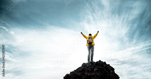 Silhouette of male on the mountain with open arms - Successful hiker exult on the top of the rock - Leadership concept