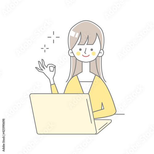 ノートパソコンの前でOKサインの女性