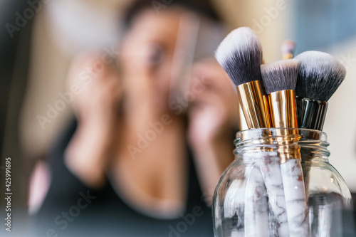 Variety of makeup brushes on a wooden table