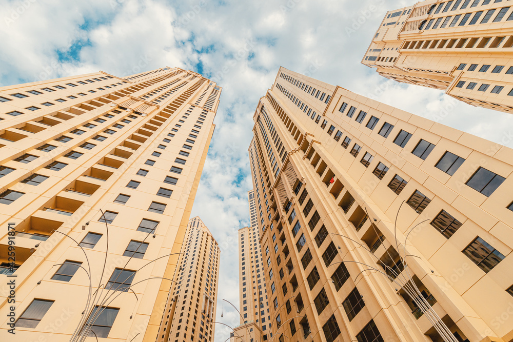 Fototapeta premium Residential real estate buildings and urban development in Dubai, UAE - bottom-up view