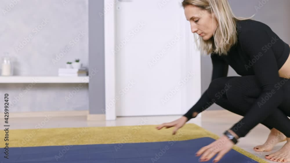 Close Up Woman Unrolling Fitness Mat and starting Exercising Workout Routine at Home in Living Room, Copy Space Close Up Woman Unrolling Fitness Mat and starting Exercising Workout Routine at Home in Living Room, Copy Space