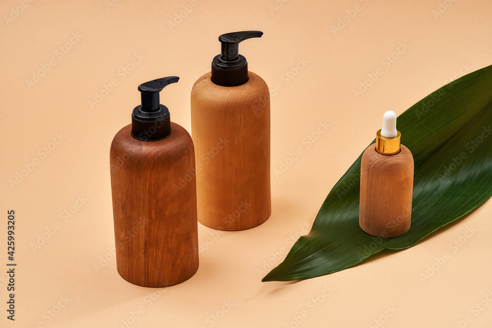 Wooden bottles or containers of different sizes isolated on beige background. Zero waste and eco conscious life Wooden bottles or containers of different sizes isolated on beige background. Zero waste and eco conscious life