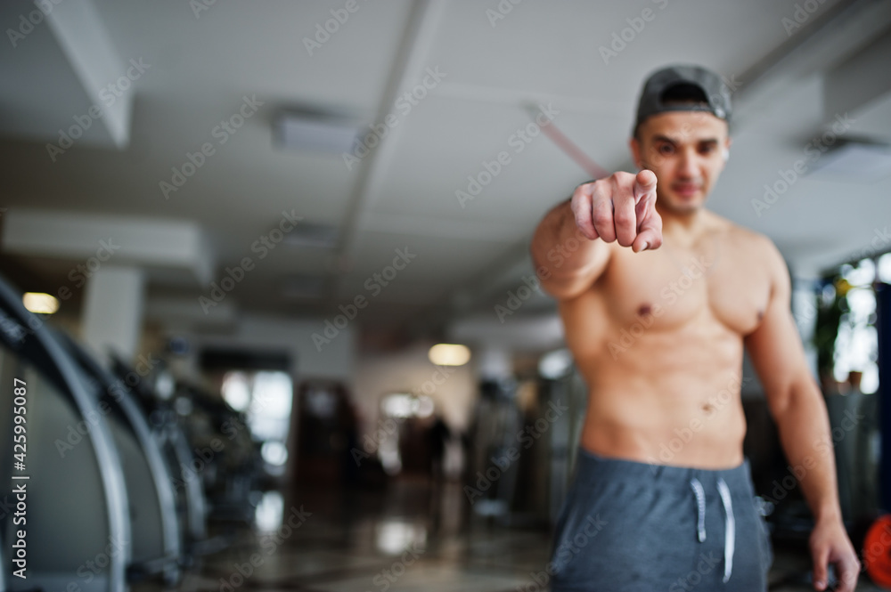 Fit and muscular arabian man posing in gym. Fit and muscular arabian man posing in gym.