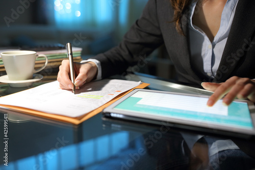 Entrepreneur hands comparing form with tablet