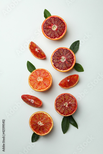 Red orange slices with leaves on white background, top view