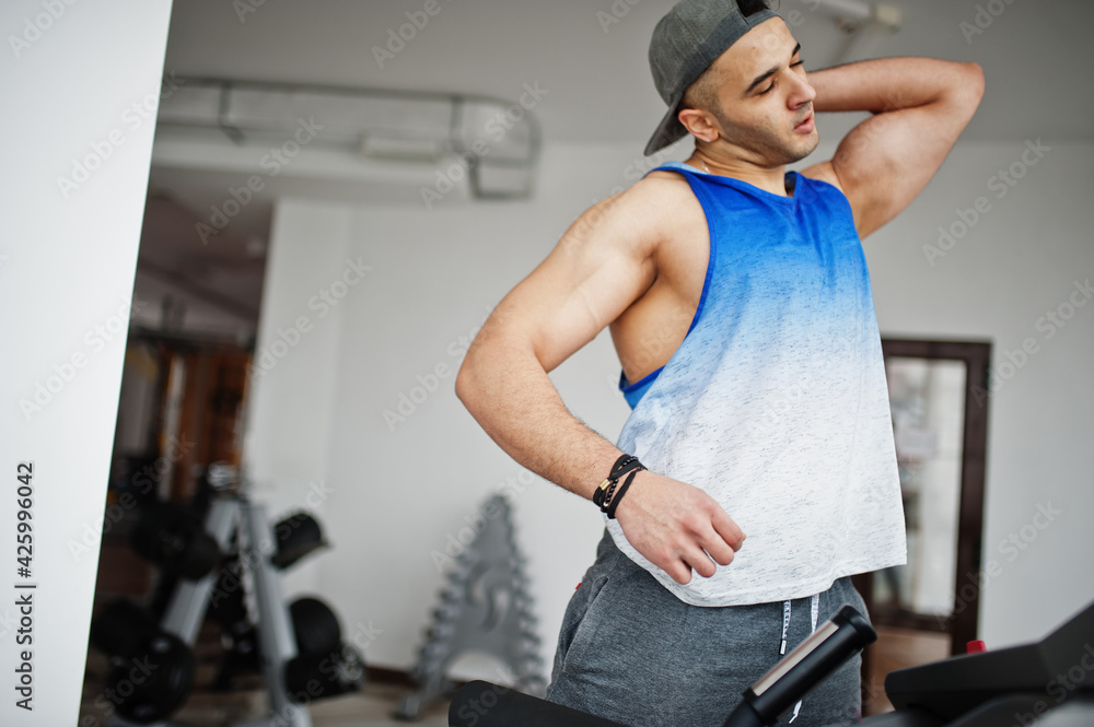 Fit and muscular arabian man running on treadmill in gym. Fit and muscular arabian man running on treadmill in gym.