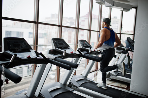 Fit and muscular arabian man running on treadmill in gym. © AS Photo Family