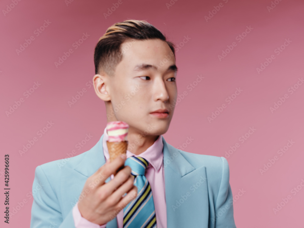 Asian guy in classic suit hairstyle ice cream pink background Asian guy in classic suit hairstyle ice cream pink background
