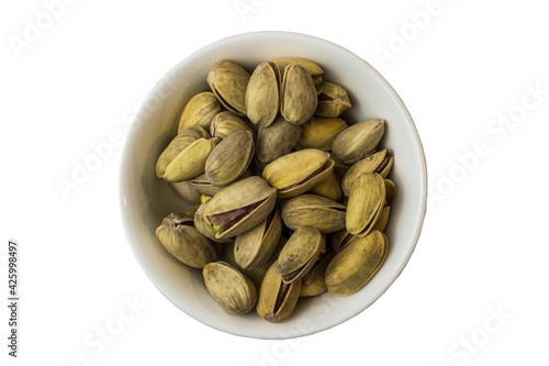 Pistachios in a white bowl on a white background