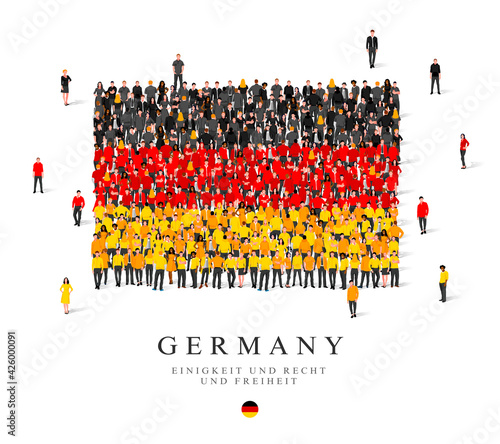 A large group of people are standing in black, red and yellow robes, symbolizing the flag of Germany.