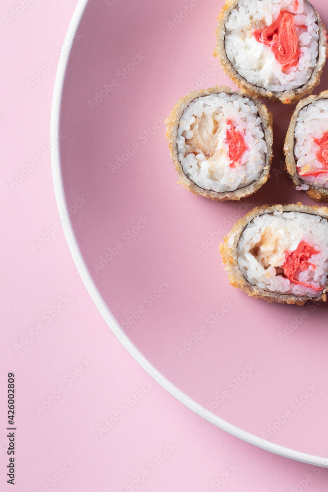 Sushi set in plate on pink background