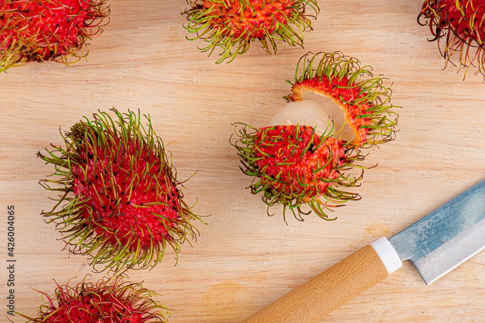 Rambutan fruit and knives on wooden table background,Close-up