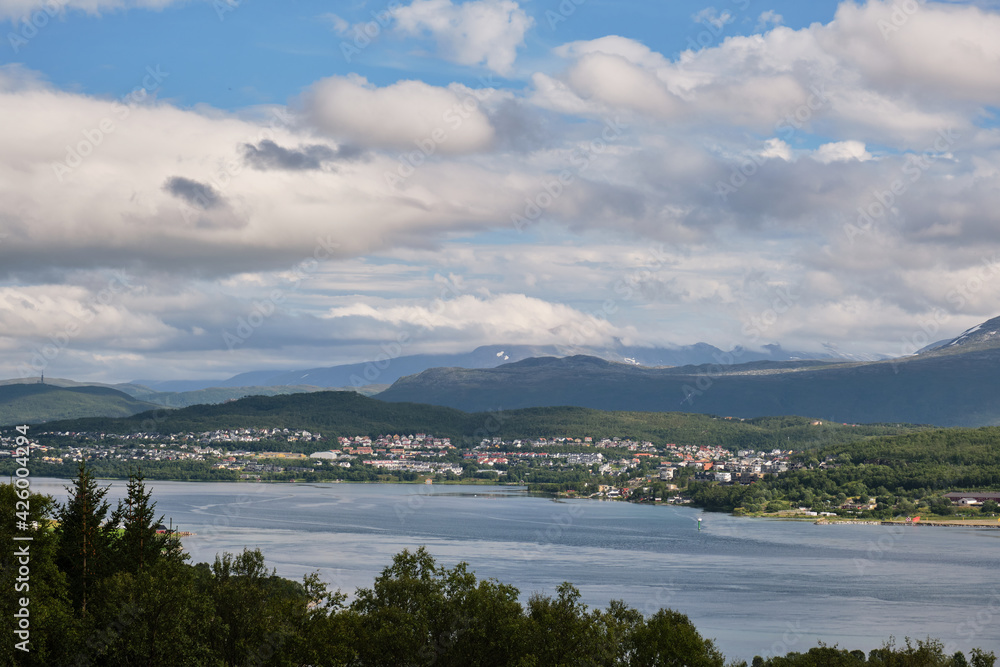 View of clouds and mountains  over the sea and the city in Tromso