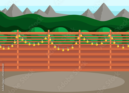 Sunny back yard with fence decorated with garland. Place for hanging out and hosting events